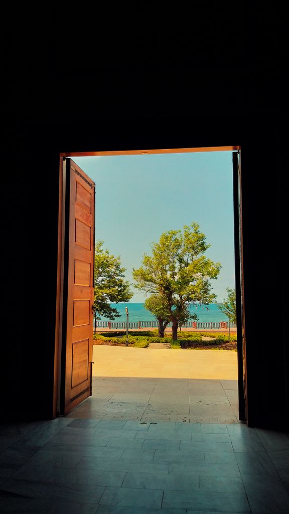 A scenic view through a doorway showing trees and the sea in Zonguldak, Türkiye.